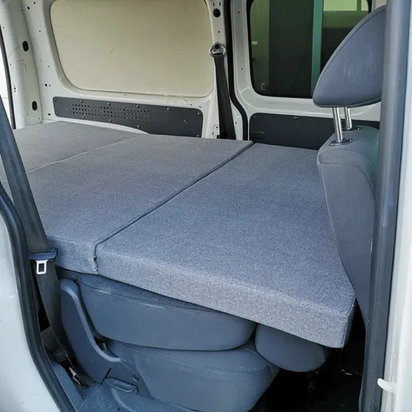 Matelas pliable gris clair installé sur les sièges arrière, idéal pour vans aménagés type Partner, Transit Connect.