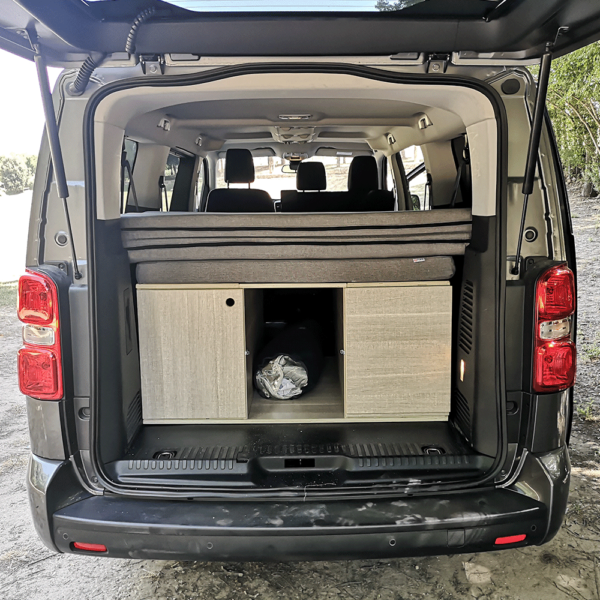 Vue intérieure du matelas déplié dans un Proace Verso, formant un grand lit arrière confortable.