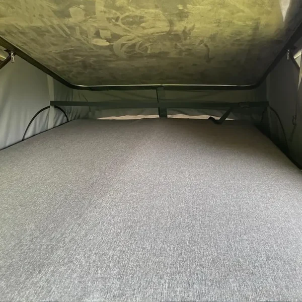Matelas installé dans l’espace nuit du toit relevable d’un van aménagé